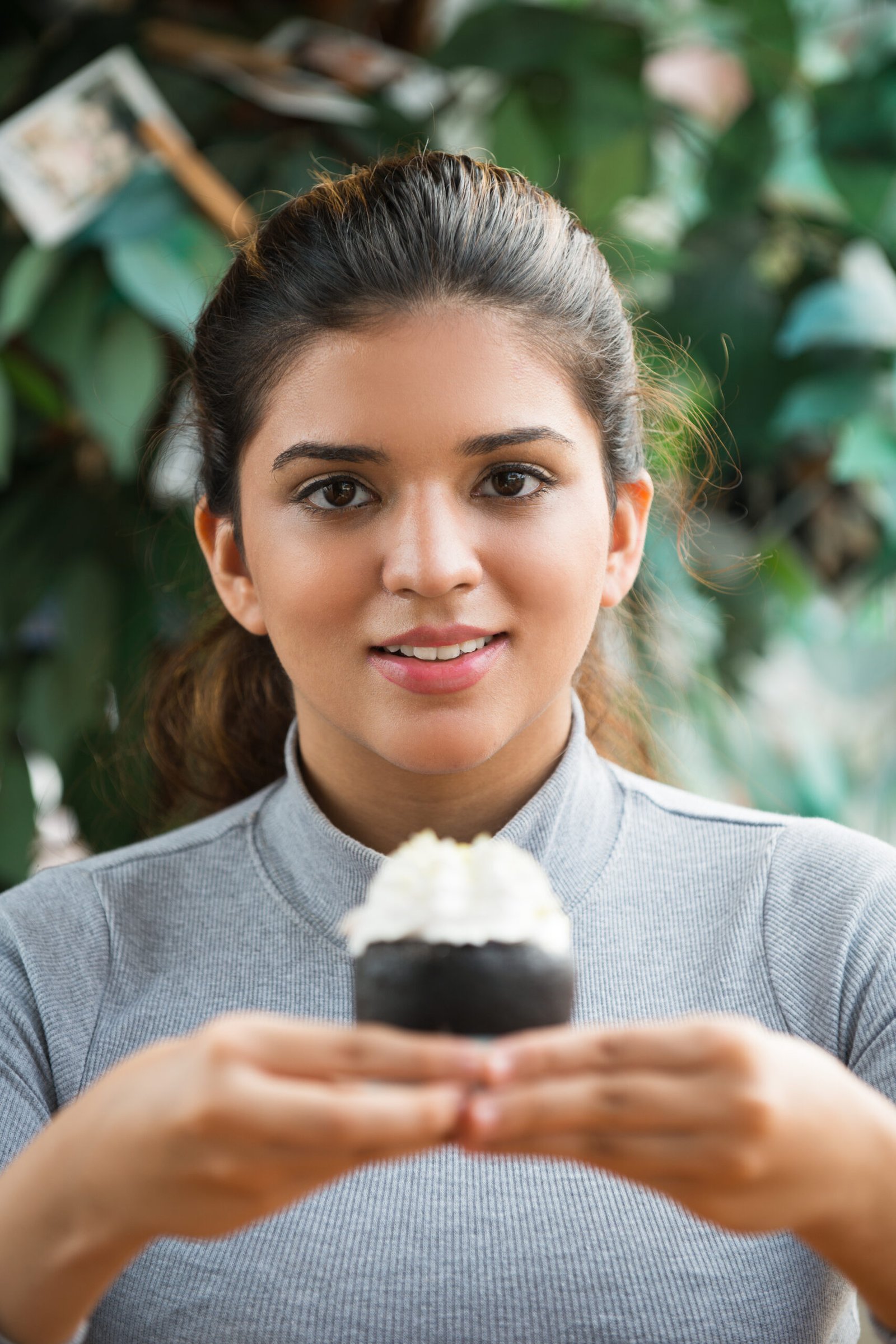 portrait of smiling young woman holding pastry